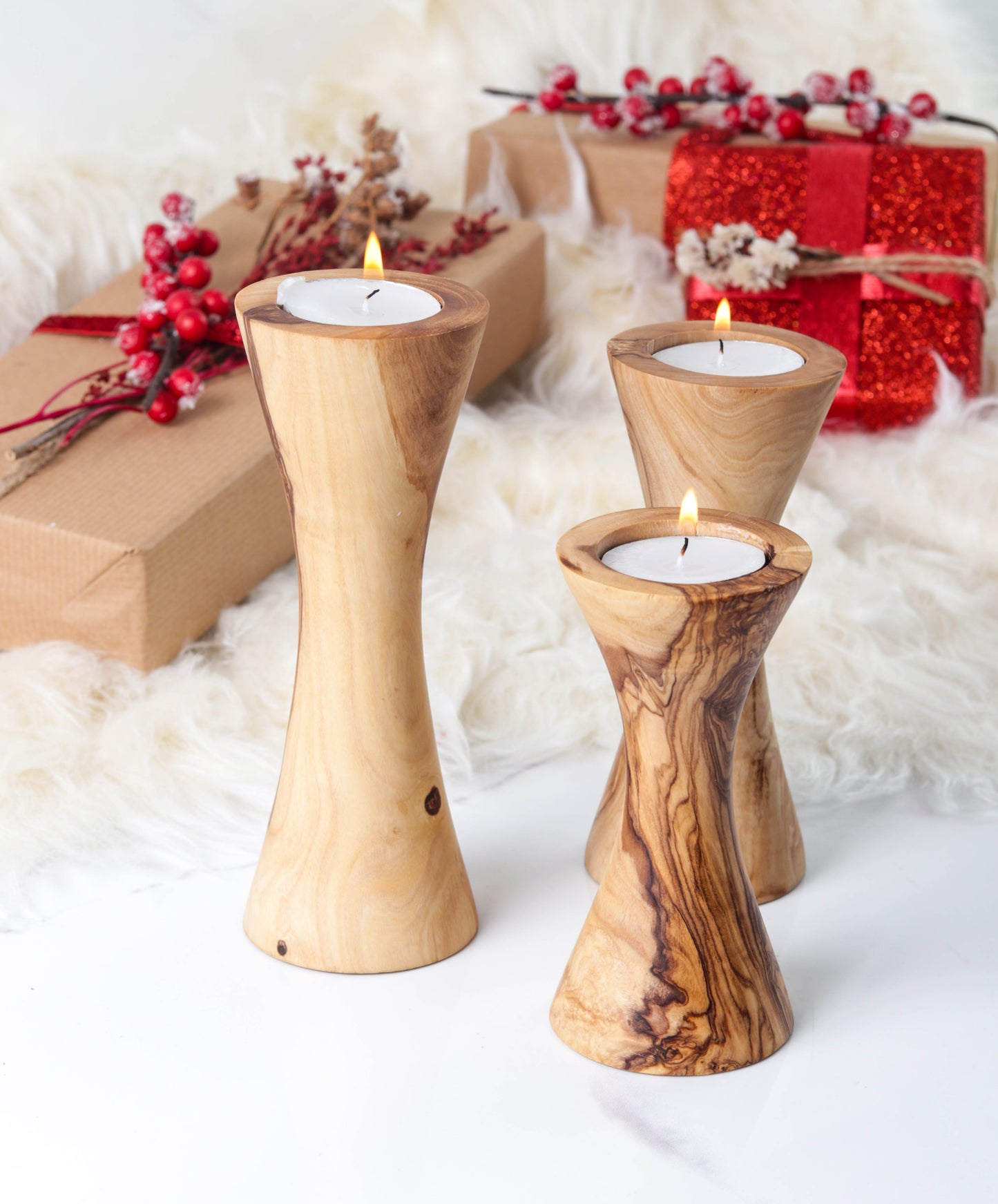 Set of three handcrafted olive wood candle holders with candles, perfect for home decor